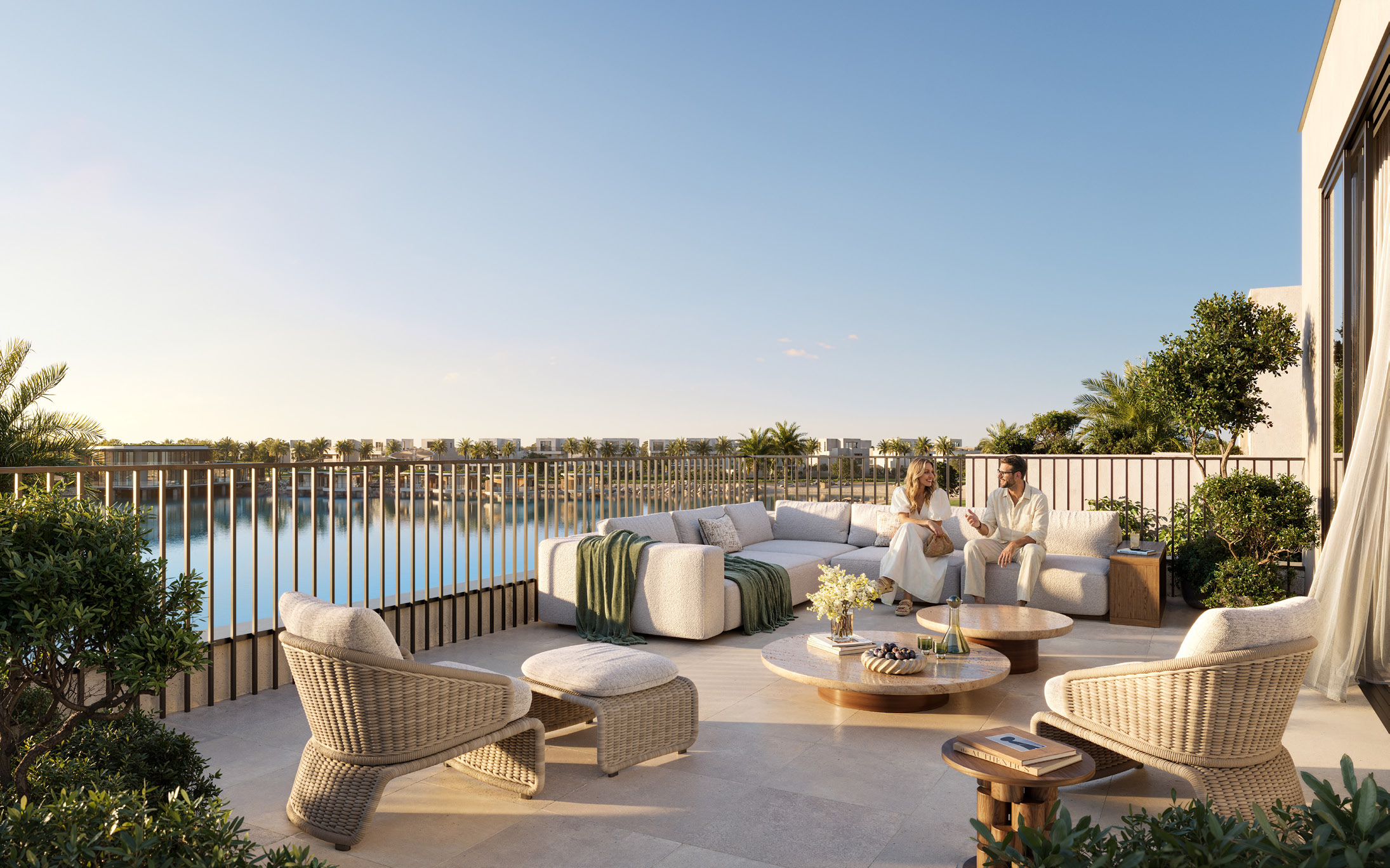 Roof terrace with sofas and woven chairs overlooking the lake